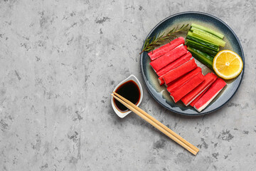 Plate with tasty crab sticks and sauce on grunge background © Pixel-Shot