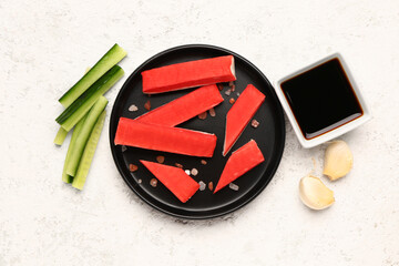 Plate with tasty crab sticks and sauce on light background © Pixel-Shot