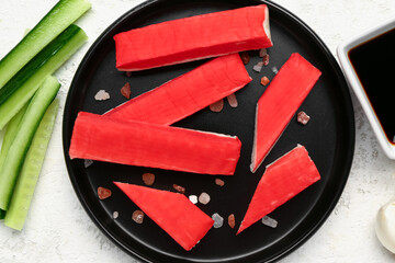 Plate with tasty crab sticks on light background © Pixel-Shot
