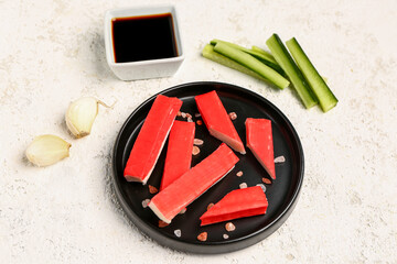 Plate with tasty crab sticks on light background © Pixel-Shot