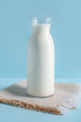 Bottle with fresh milk on blue background