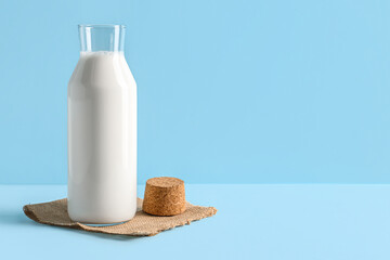 Bottle with fresh milk on blue background