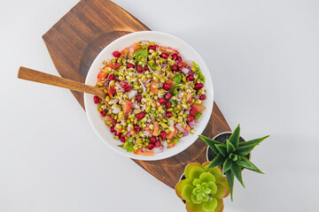 Sprouting green gram bean Indian salad with Onion, coriander leaf , green chilli , Pomegranate and tomatoes. Indian sprouting gram bean salad with isolated background, Healthy eating concept.