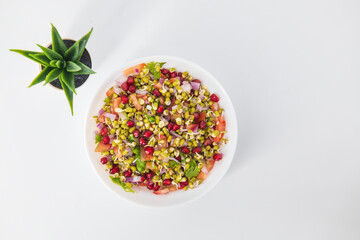 Sprouting green gram bean Indian salad with Onion, coriander leaf , green chilli , Pomegranate and tomatoes. Indian sprouting gram bean salad with isolated background, Healthy eating concept.