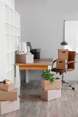 Workplace with cardboard boxes in office on moving day