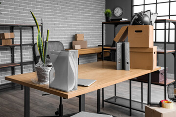 Workplace with cardboard boxes in office on moving day