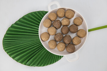 Fresh home made urad dal and millet laddu isolated and decorated. Locally called Urad Dal Ladoo, Ulundu urundan, Ulundu laddu, Kambu laddu. Selective focused millet ladoo. ...