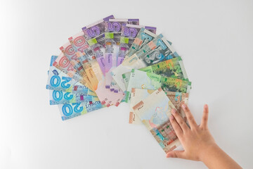 Selective focused , Full set of Kuwaiti Dinar bank paper notes. Kuwait dinar bank notes 0.25KWD, 0.5KWD, 1KWD, 5KWD, 10 KWD and 20 KWD. Kid trying to take the Kuwait dinar bank notes