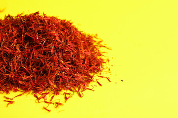 Fototapeta premium Pile of saffron on yellow background
