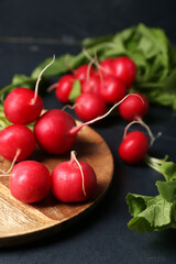 Plate of ripe radish on dark background, closeup