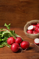 Bunch of ripe radish with green leaves on wooden background