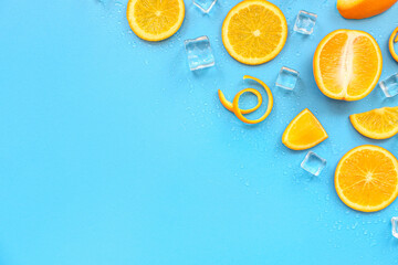 Orange pieces with ice cubes on blue background