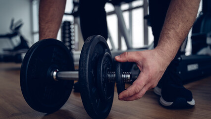 an athlete in the gym is engaged with dumbbells