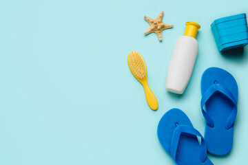 Sunscreen cream for children with beach accessories on blue background