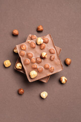 Sweet tasty chocolate with nuts on  brown background