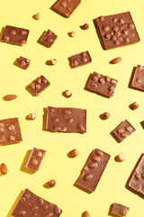 Sweet tasty chocolate with nuts on  yellow background