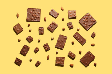 Sweet tasty chocolate with nuts on  yellow background