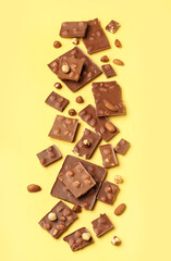 Sweet tasty chocolate with nuts on  yellow background