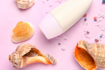 Deodorant with shells and sea salt on pink background
