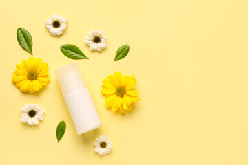 Deodorant with flowers and leaves on yellow background
