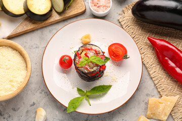 Plate with tasty baked Eggplant Parmesan on grunge background