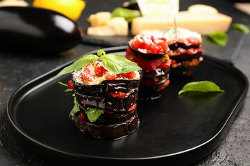 Tray with tasty baked Eggplant Parmesan on dark background