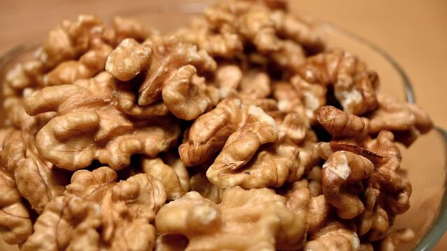 closeup of a bowl of walnuts on table, rotation