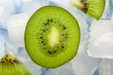 Sliced fresh kiwi and ice cubes on blue background