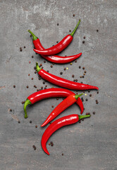 Fresh chili peppers with peppercorns on dark background