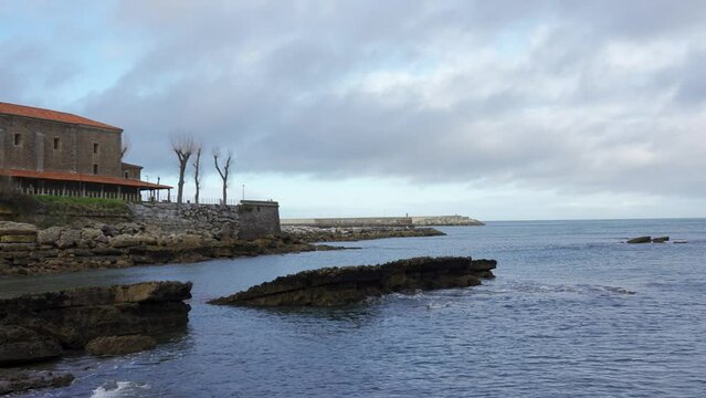 Old stone church by the sea in the fishing village of Luanco, Asturias, Spain.