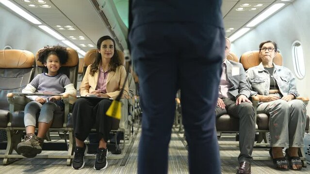 Flight attendants show how to use safety devices and recommend emergency exits.