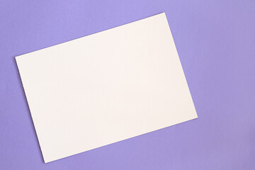 white paper sheet on purple background with free space
