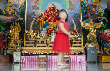 Blurry girl in front of altar in Buddhist temple, Thailand