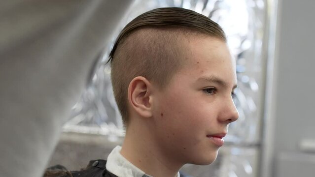 Close-up of barber doing haircut at hair salon or barber shop