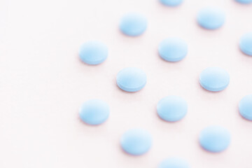 Pharmaceutical medicine pills, tablets and capsules laid out in a grid on bright light pink background . Medicine creative concepts. Minimal style with colorful paper backdrop.