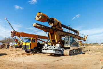 The construction site for the highway with heavy equipment. Two rotational exercises, lifting crane