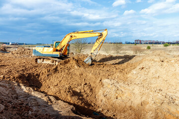 Excavator dig the trenches at a construction site. Trench for laying external sewer pipes. Sewage...