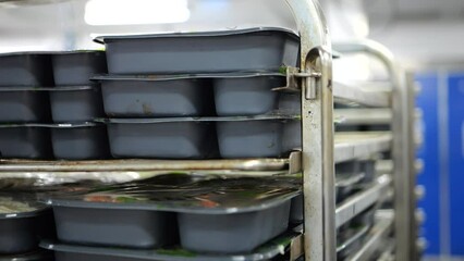 Close up of workers hands arranging food boxes in catering food factory
