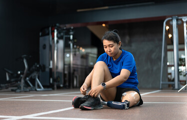 Fototapeta na wymiar Asia woman with prosthetic leg exercise at gym or fitness 