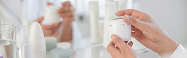 Beautiful woman hands opening a jar of cream