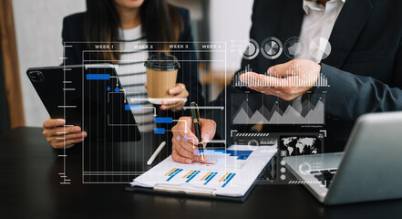 Businessman hand Project manager working and update tasks and Gantt chart scheduling virtual diagram.with smart phone, tablet and laptop in office..