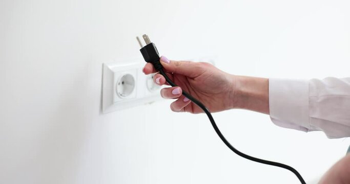 Woman tries to wire wrong plug to socket on white wall in office room. Lady fails connecting appliance to electrical network. Technical details