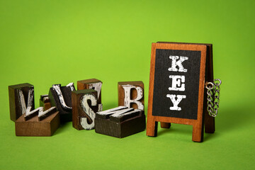 KEY, Keep Educating Yourself Concept. Miniature chalkboard and alphabet blocks on a green background