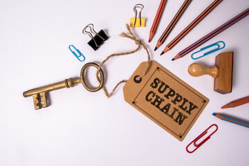 Supply Chain. Key with cardboard price tag and office supplies on white background
