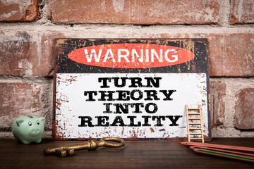 Turn Theory Into Reality. Warning sign on wooden texture office desk