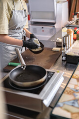 The chef breads the cheese in flour before frying it in a pan in restaurant kitchen