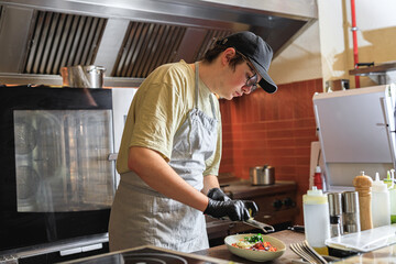 Professional chef grates Parmesan cheese on ready dish in restaurant kitchen