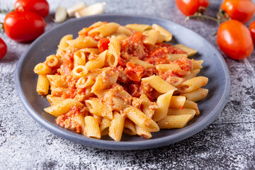 Pennette with tuna and cherry tomatoes. Typical dish of traditional Italian and Mediterranean cuisine. Healthy and balanced dish suitable for both lunch and dinner.