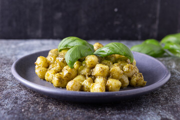 potato gnocchi with homemade basil pesto. Typical dish of traditional Italian cuisine, suitable for those who follow a vegetarian diet.