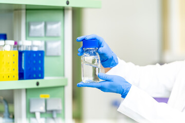 chemical substances in glass flask in the hand of a scientist in a research laboratory